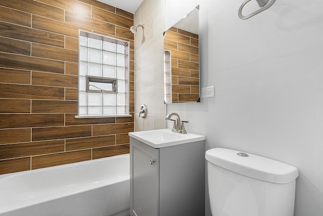 full bathroom with vanity, tiled shower / bath, and toilet