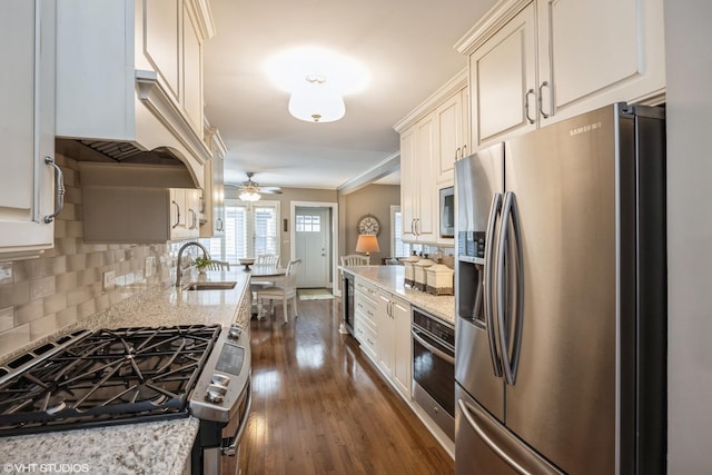 kitchen with light stone countertops, sink, ceiling fan, and stainless steel appliances