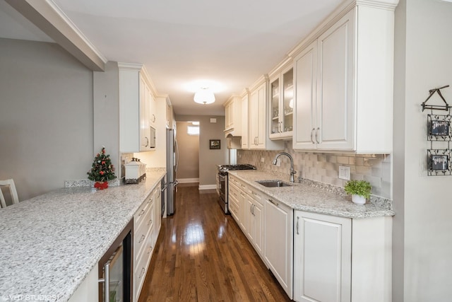 kitchen featuring wine cooler, light stone counters, sink, and appliances with stainless steel finishes