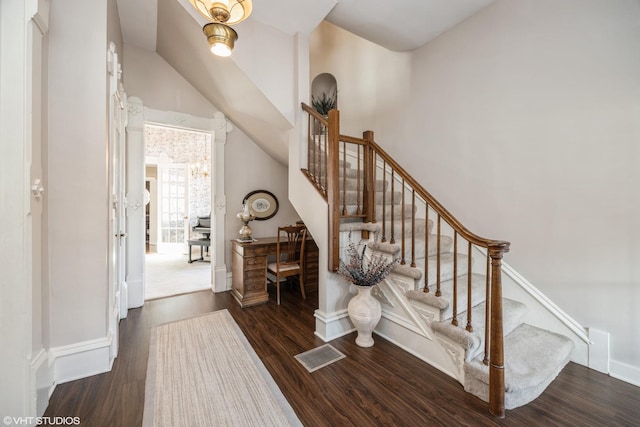 stairs featuring a towering ceiling and hardwood / wood-style flooring