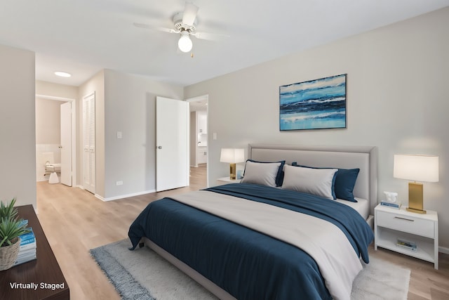 bedroom with ensuite bath, ceiling fan, and light hardwood / wood-style flooring