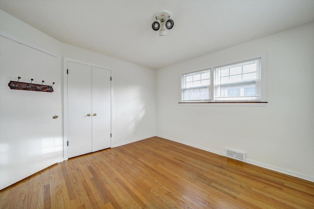 unfurnished bedroom featuring a closet and light wood-type flooring