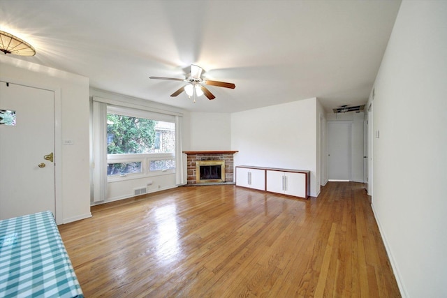 unfurnished living room with a fireplace, light hardwood / wood-style floors, and ceiling fan