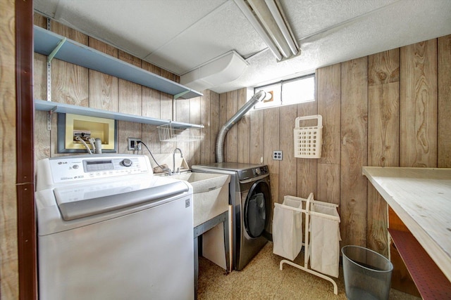 laundry room featuring washer and clothes dryer and wooden walls