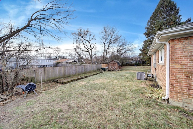 view of yard with central AC unit and a storage shed