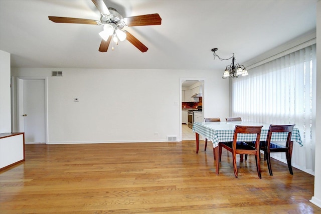 dining area featuring ceiling fan with notable chandelier and light wood-type flooring