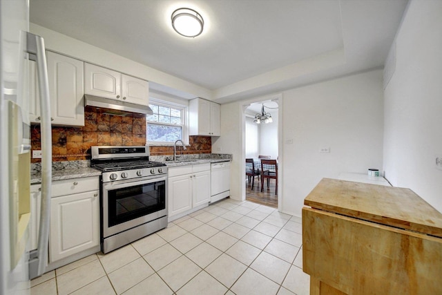 kitchen featuring backsplash, white dishwasher, sink, stainless steel stove, and white cabinetry