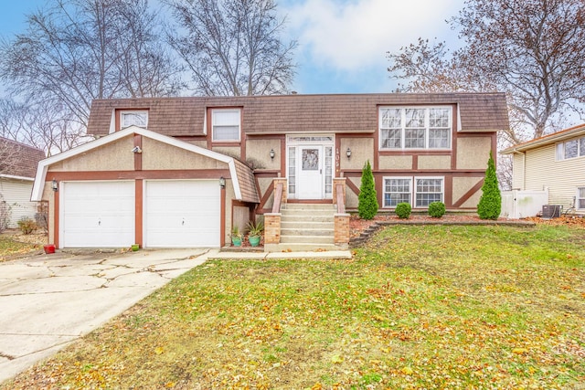 view of front of home with a garage, central air condition unit, and a front lawn