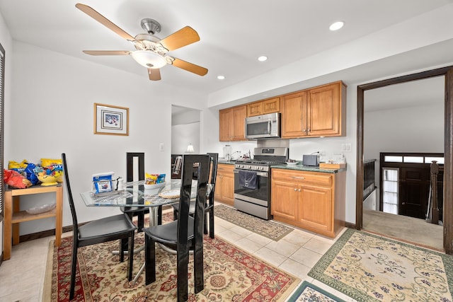 kitchen featuring ceiling fan, light tile patterned flooring, and stainless steel appliances