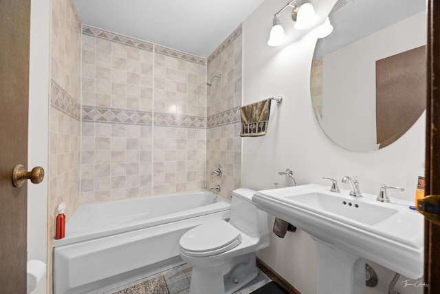 full bathroom featuring sink, tiled shower / bath combo, and toilet