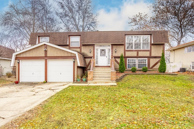 view of front of home featuring cooling unit, a garage, and a front yard