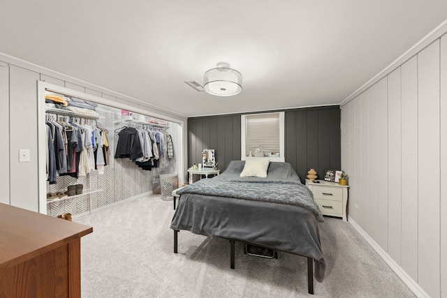 carpeted bedroom featuring a closet and wood walls