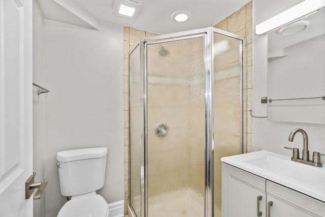 bathroom with toilet, an enclosed shower, and vanity