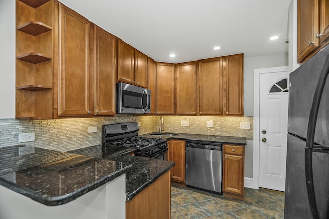 kitchen with black appliances, sink, dark stone countertops, tasteful backsplash, and kitchen peninsula