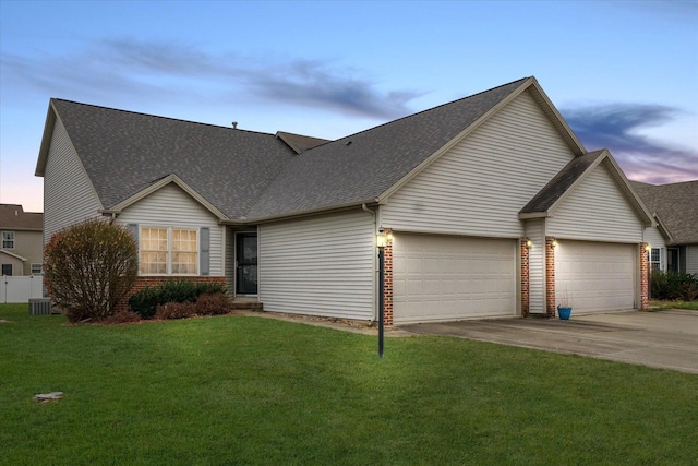 view of front of property with a lawn, cooling unit, and a garage