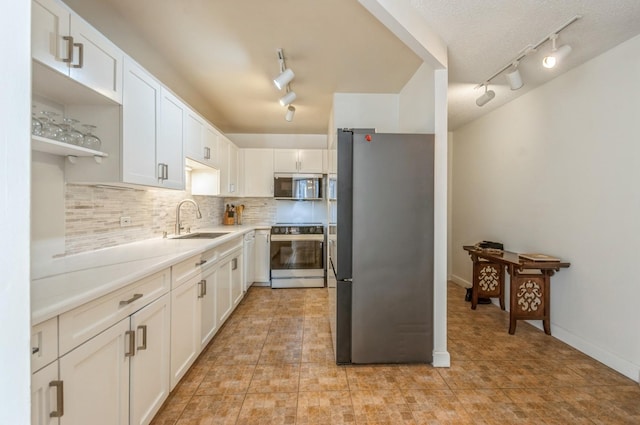 kitchen featuring sink, white cabinetry, stainless steel appliances, and track lighting