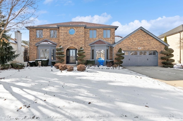 view of front of home featuring a garage, driveway, and brick siding