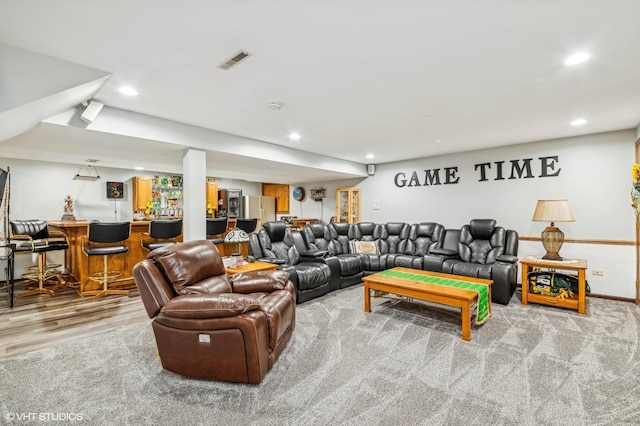 living room featuring recessed lighting, visible vents, light wood finished floors, and a dry bar