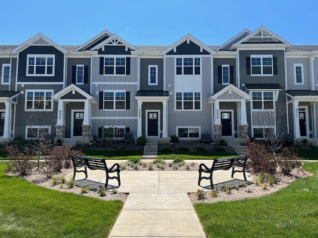 view of front of home with central AC and a front lawn