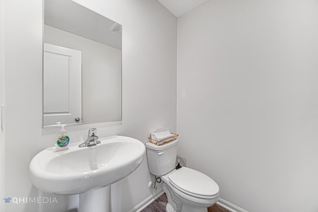 bathroom featuring hardwood / wood-style flooring, sink, and toilet