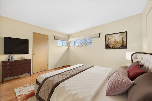 bedroom with light hardwood / wood-style flooring and lofted ceiling