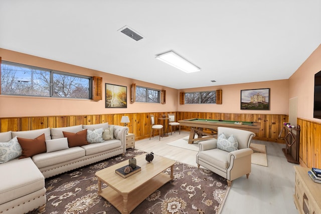 living room featuring wooden walls, light hardwood / wood-style flooring, and pool table