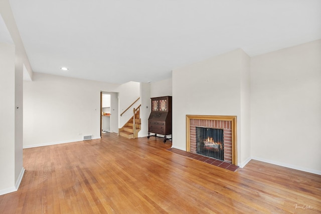 unfurnished living room featuring a fireplace and light hardwood / wood-style flooring