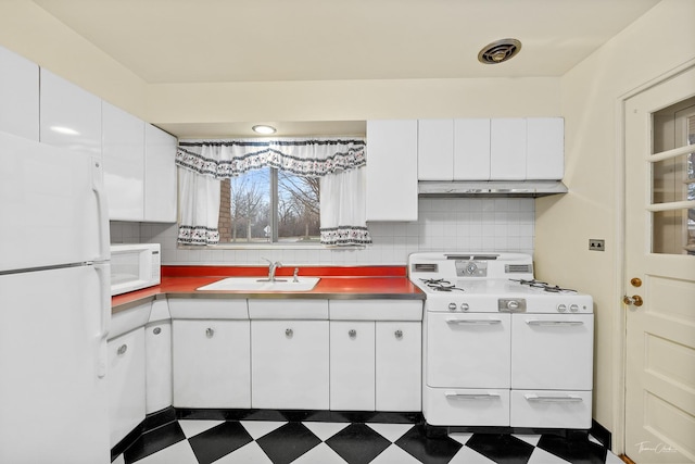 kitchen with tasteful backsplash, white cabinetry, sink, and white appliances