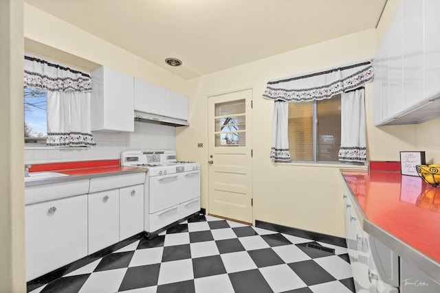 kitchen with white range oven, decorative backsplash, sink, and white cabinets