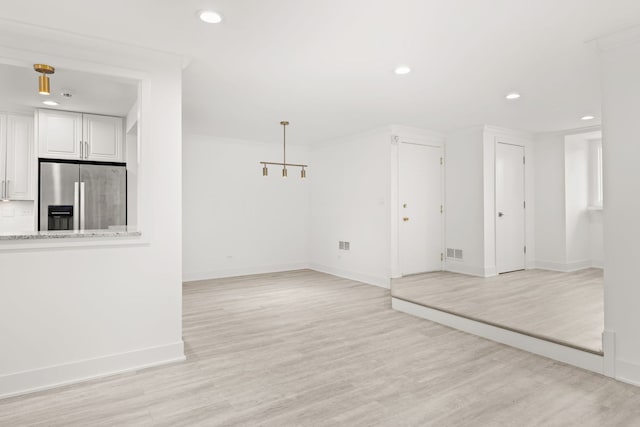 unfurnished living room with light hardwood / wood-style floors and ornamental molding