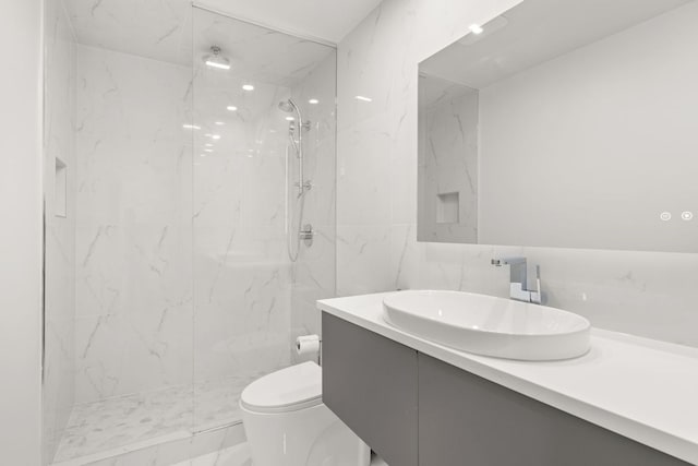 bathroom with toilet, vanity, tile walls, and tiled shower