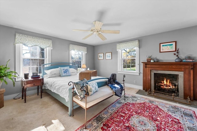 carpeted bedroom featuring multiple windows and ceiling fan