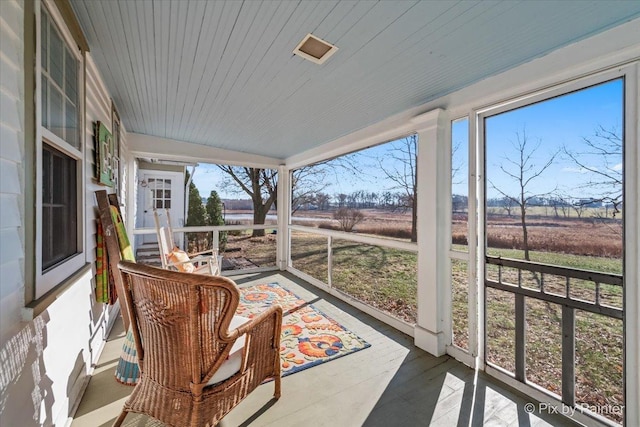 sunroom / solarium featuring a rural view and wooden ceiling