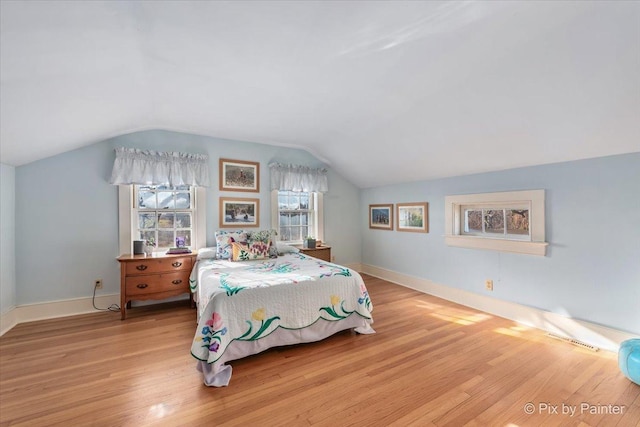 bedroom with light hardwood / wood-style floors and vaulted ceiling