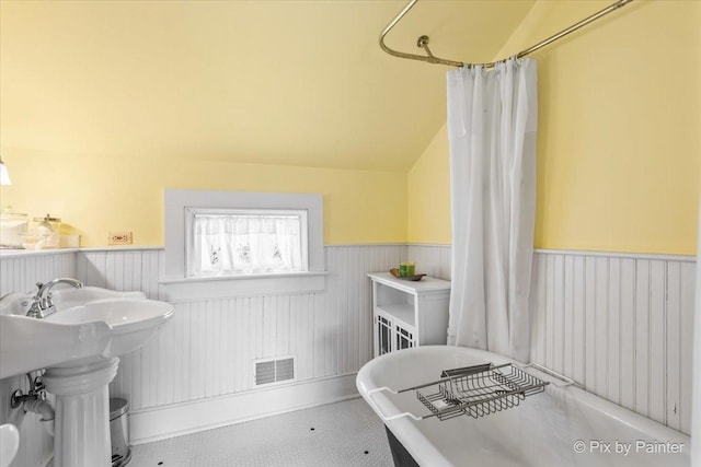 bathroom with shower / tub combo and vaulted ceiling