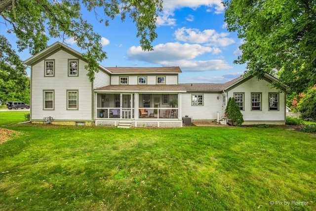 rear view of house with a lawn and a sunroom