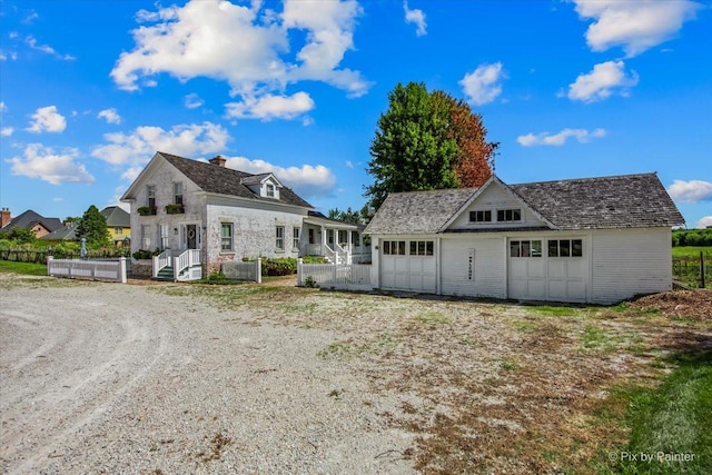 back of property featuring a garage and an outdoor structure