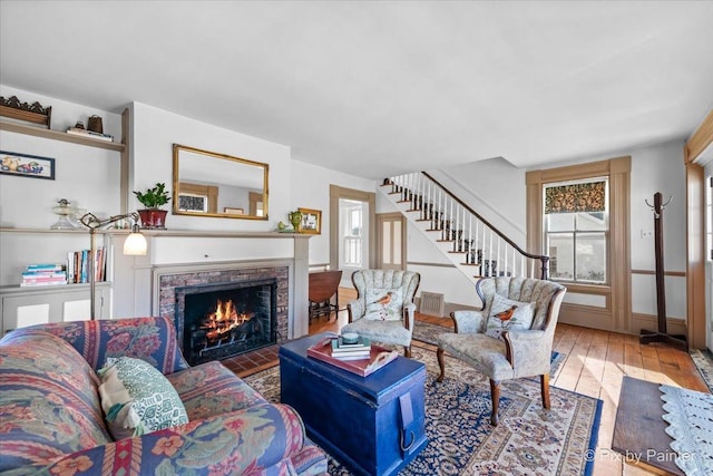 living room featuring hardwood / wood-style floors and a brick fireplace