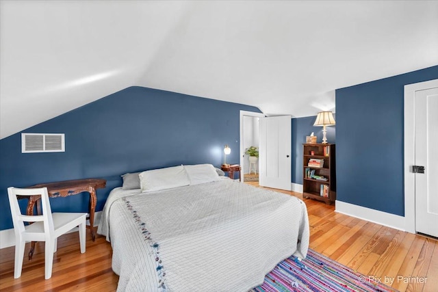 bedroom featuring wood-type flooring and vaulted ceiling