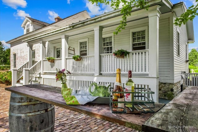 back of house featuring a porch