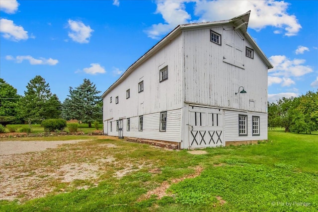 view of home's exterior featuring a lawn and an outbuilding