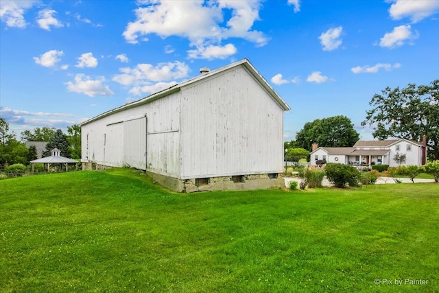 view of home's exterior featuring a yard and an outbuilding