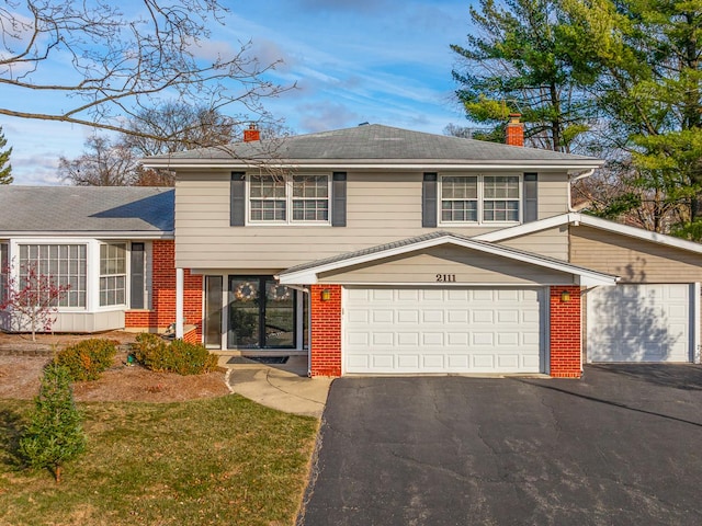 split level home featuring a garage and a front lawn