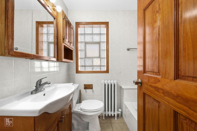 bathroom with vanity, radiator, tile patterned flooring, toilet, and tile walls