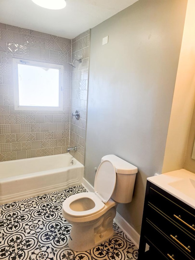 full bathroom with tile patterned flooring, vanity, tiled shower / bath combo, and toilet