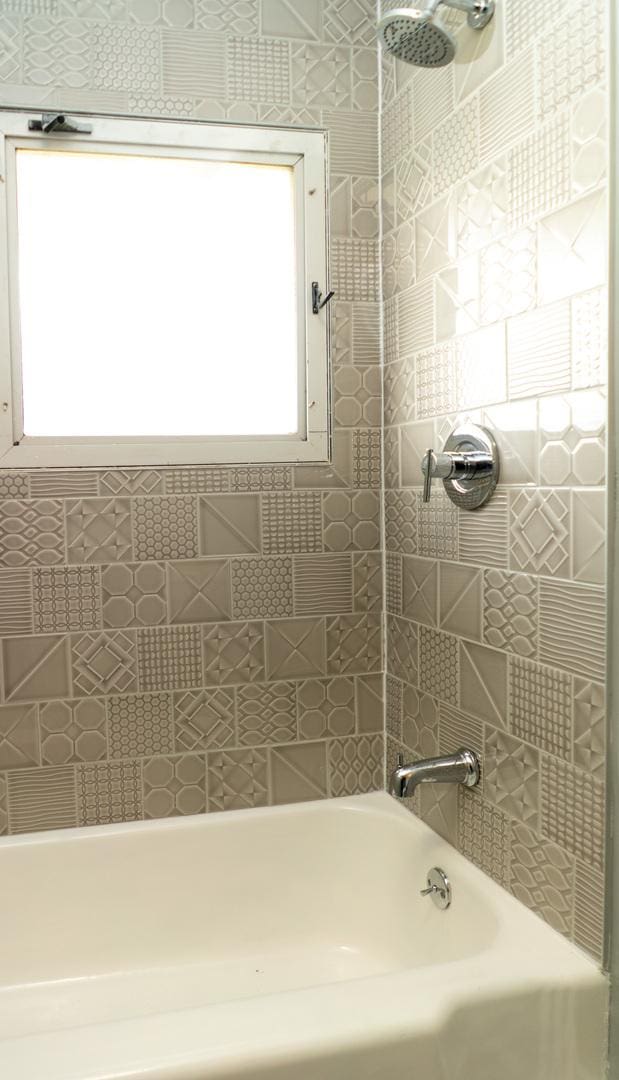 bathroom featuring tiled shower / bath