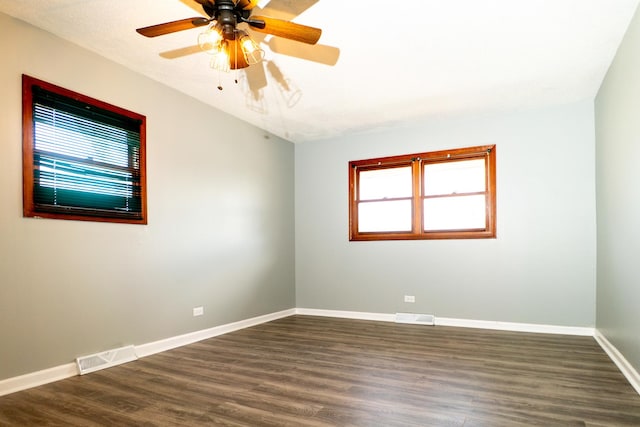 spare room featuring ceiling fan and dark wood-type flooring