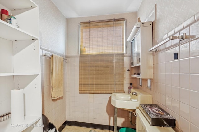 bathroom with sink and tile walls