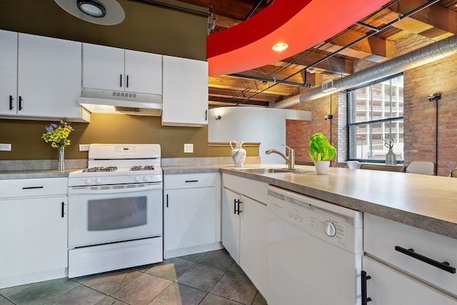 kitchen featuring white cabinetry, sink, brick wall, and white appliances