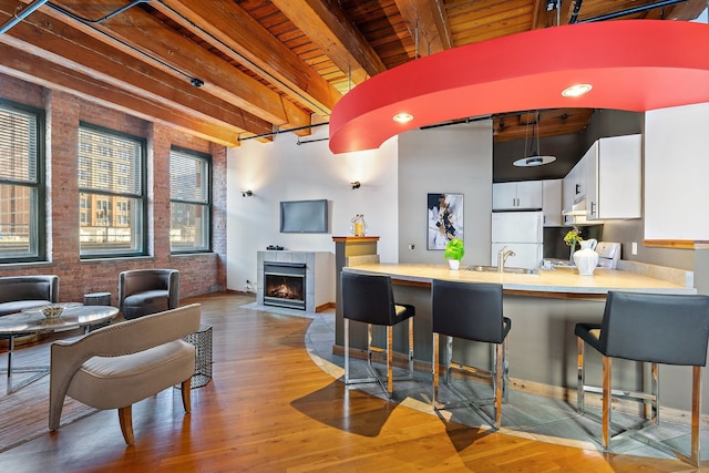 kitchen featuring beamed ceiling, light wood-type flooring, white cabinets, and wood ceiling